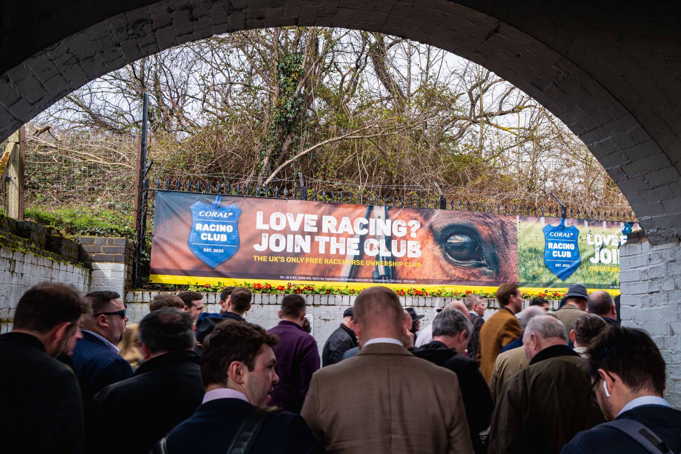 “Love racing? Join the club” banner seen through the station archway